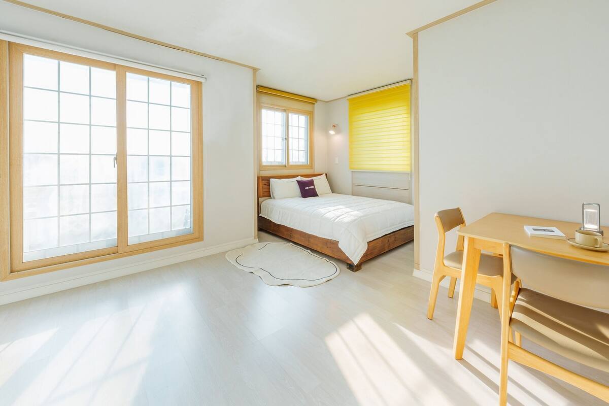 Ein Schlafzimmer mit einem Bett, einem Schreibtisch und einem Sessel.