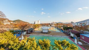 A basketball court with a pavilion, surrounded by trees and buildings. - Geoje Peugeot Gomsol Petfriendly Pension (Geoje)
