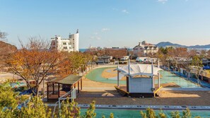 Un parque costero con un área de juegos, canchas deportivas y una zona de playa.
