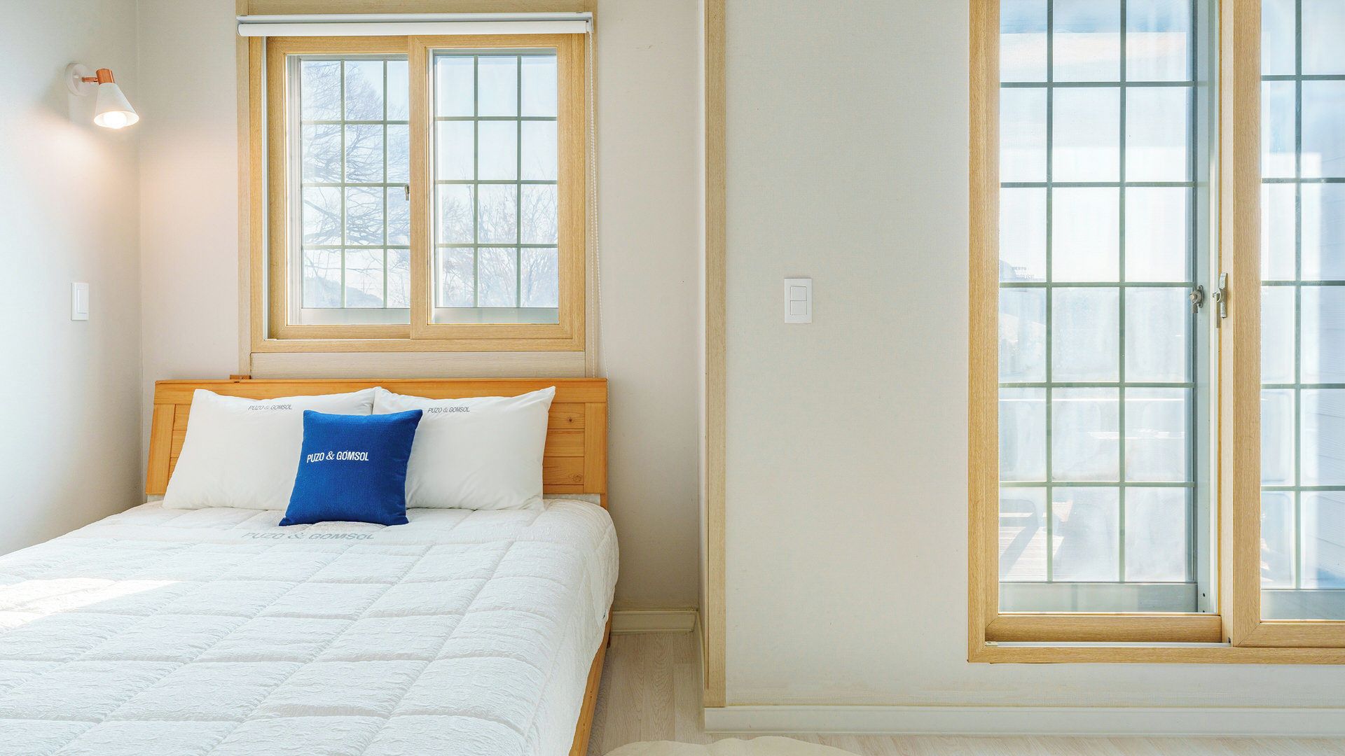 A bedroom with a bed, a window, and a door.
