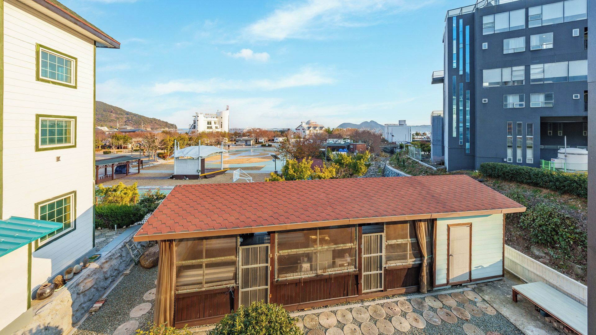 A traditional Japanese house with a tiled roof, wooden sliding doors, and a small garden area.