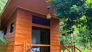 Une cabane en bois dotée d’un balcon et d’un escalier menant à l’entrée.