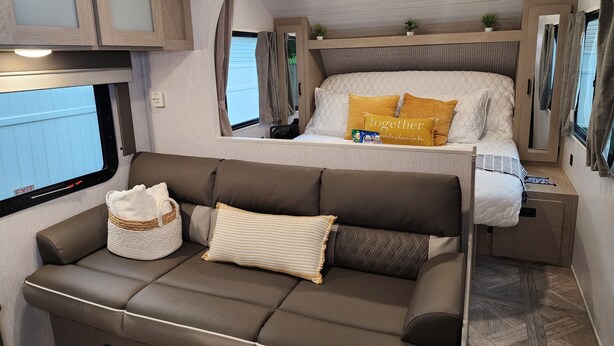 A cozy RV interior with a bed, a sofa, and a window. - The Salem Experience 15 Min from Downtown  (Savannah)