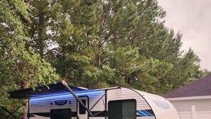 A mobile home with a blue awning, a sliding door, and a small attached utility vehicle. - The Salem Experience 15 Min from Downtown  (Savannah)
