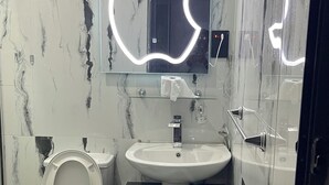 A bathroom with a toilet, sink, and mirror. - Charming 2 bedroom apartment in nice area in  Lagos with WiFi, AC & security (Lagos)