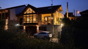 A two-story house with a stone facade, a balcony, and a car parked in front. - Casa Valparón Porrúa Llanes - Terraces and Views (Porrua)