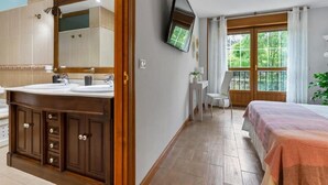 A bathroom with a double sink vanity, a mirror, and a television mounted on the wall. - Casa Valparón Porrúa Llanes - Terraces and Views (Porrua)