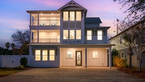 A two-story house with a covered front porch, a balcony on the upper floor, and a garage entrance. - 🌅 Saltwater Sunsets | Private Pool & Close to Beach | Dog Friendly* | FREE Excursions ☀️ (Destin)