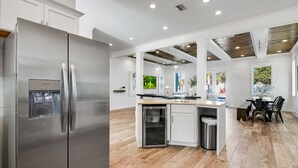 A modern kitchen with a stainless steel refrigerator, a built-in oven, and a small trash bin. - 🌅 Saltwater Sunsets | Private Pool & Close to Beach | Dog Friendly* | FREE Excursions ☀️ (Destin)