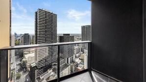 A high-rise building with a view of the cityscape through a balcony.