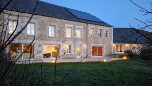 A stone building with multiple windows and doors, a well-maintained lawn, and solar panels on the roof. - 7 bedroom beautiful home in Flaignes-Havys (Flaignes-Havys)