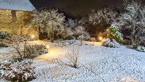 A snow-covered garden with pathways and trees, illuminated by ground lights. - 7 bedroom beautiful home in Flaignes-Havys (Flaignes-Havys)