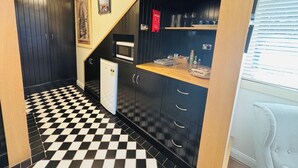 A compact kitchen with black cabinets, a microwave, and a small refrigerator. - Leura's Magical Manderley - Studio Room (Leura)
