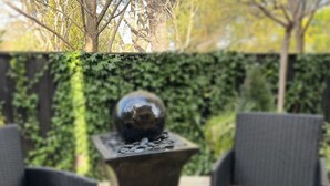 An outdoor seating area with two wicker chairs and a table with a decorative sphere. - Leura's Magical Manderley - Studio Room (Leura)