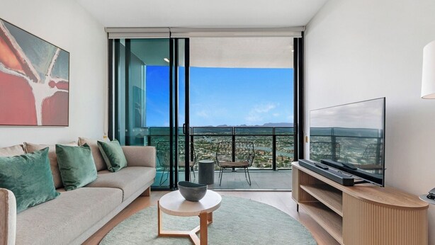 A modern living room with a sofa, a coffee table, and a TV.