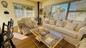 Un salon avec un canapé beige, une table basse en verre et une cheminée.