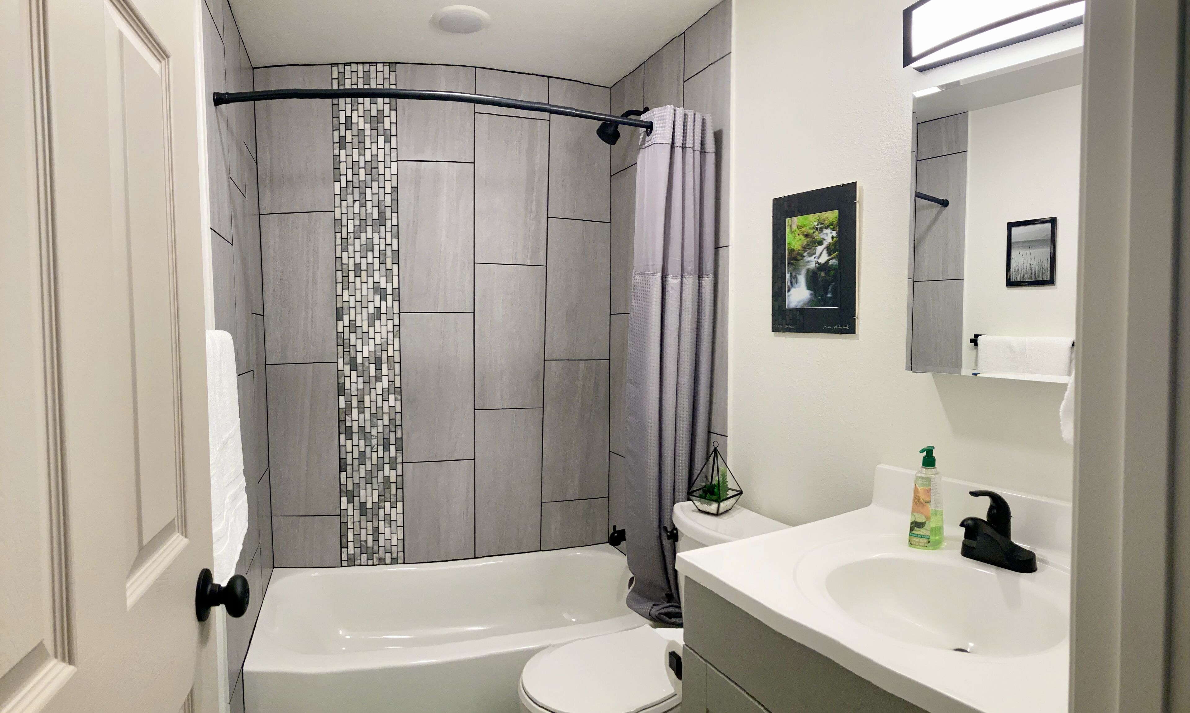 Un baño moderno con ducha, inodoro y lavabo.