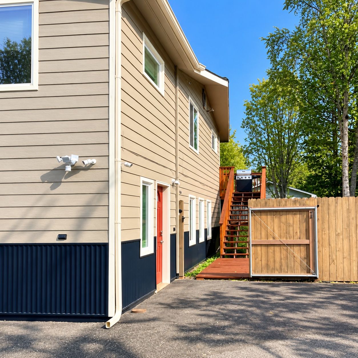 A two-story building with a covered outdoor area and a wooden fence.