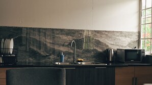 A kitchen with a sink, faucet, and a microwave.