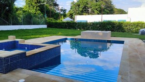 A rectangular swimming pool with a tiled interior and a wooden deck area. - Thomas' Ranch (Nilo)