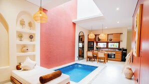 Un interno moderno con una piccola piscina, una zona pranzo e una cucina.