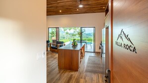 Una cocina moderna con suelo de madera, una isla central y vistas a exuberante follaje.
