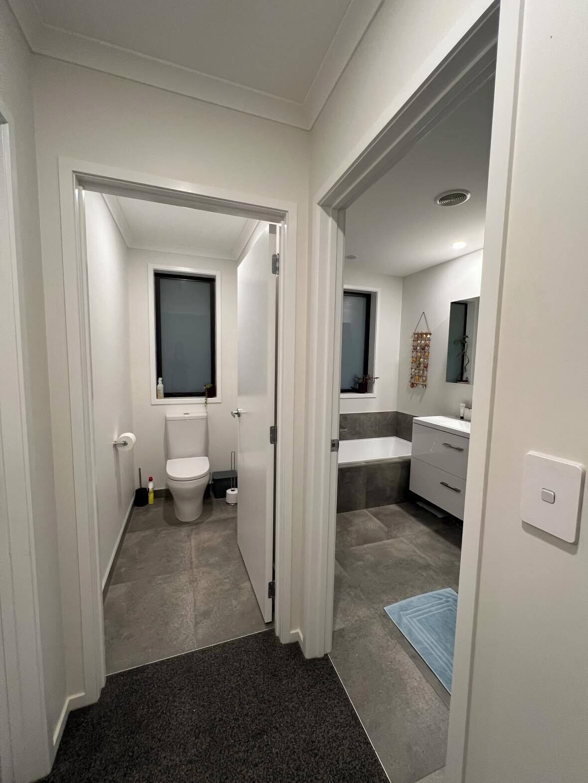 Un baño moderno con inodoro, lavabo y zona de ducha.