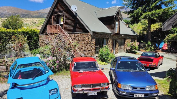 Three cars parked in front of a stone house with a sloped roof and a satellite dish. - Riverside Retreat in beautiful Arrow Junction (Arrow Junction)