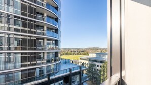 A modern multi-story building with a curved facade, large windows, and balconies. - Modern 1 Bedroom Apartment in Philip Canberra (Phillip)