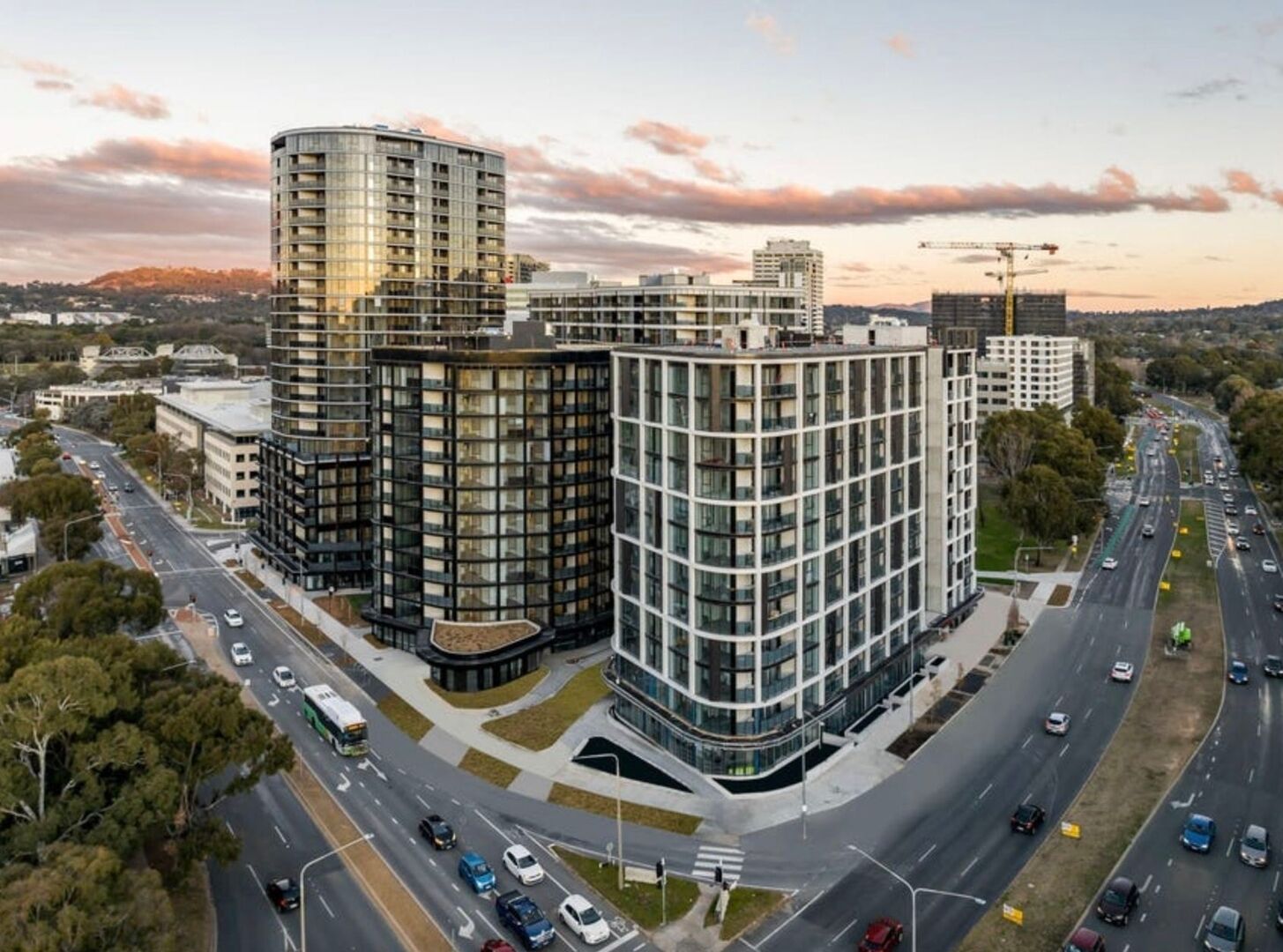 A modern urban building complex with multiple high-rise structures, surrounded by roads and greenery.