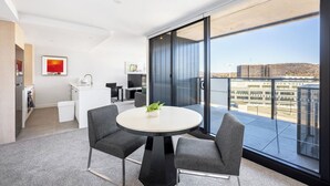 A modern apartment with a balcony, a dining area, and a view of an airport.