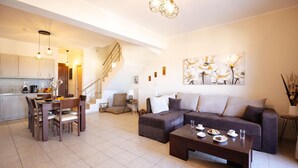 A modern living room with a sofa, coffee table, and dining area.