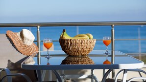 A table with a woven basket containing bananas, two glasses of orange juice, and a straw hat.