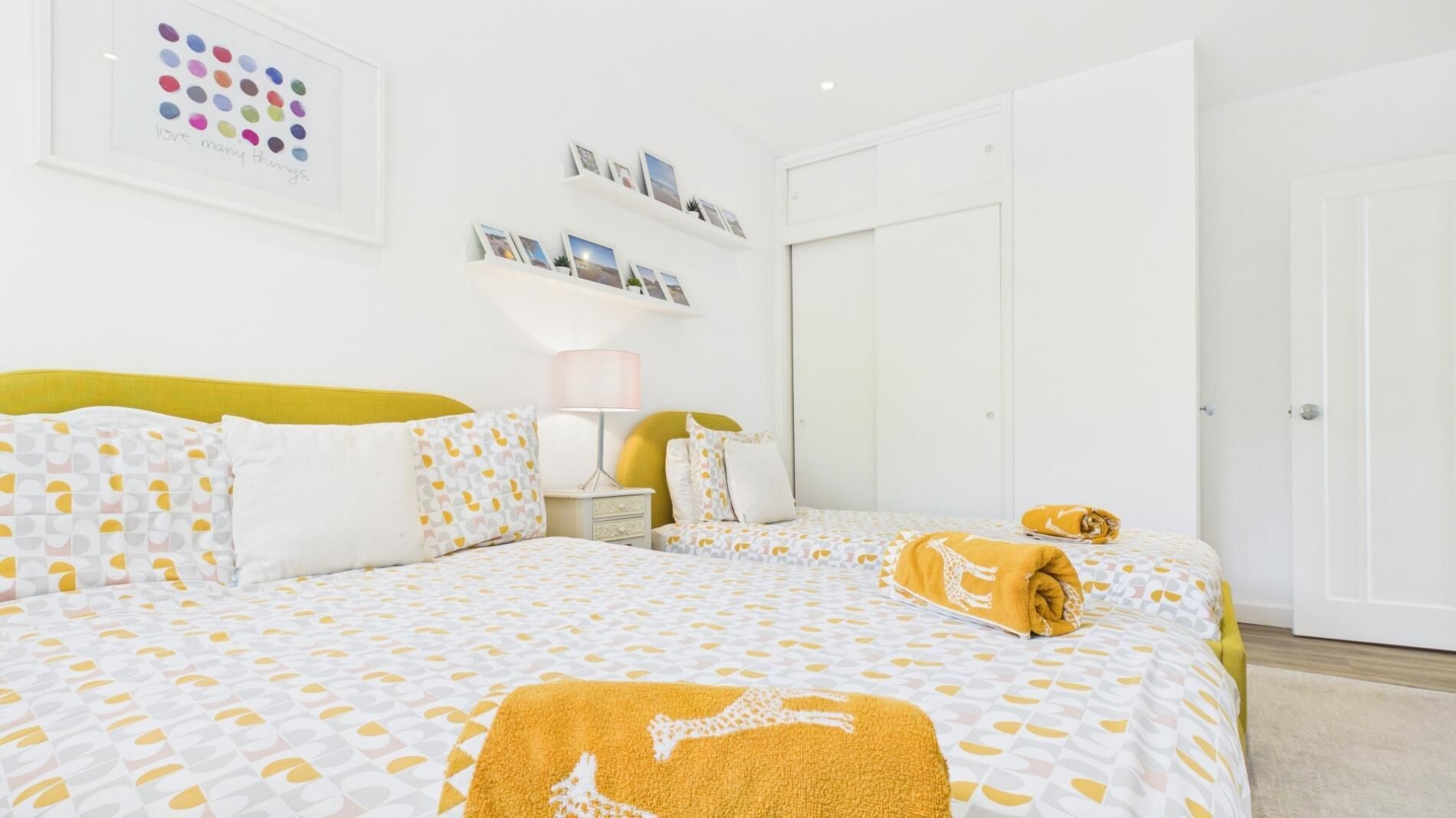 Une chambre à coucher avec un lit, une table de chevet, une lampe et une porte.