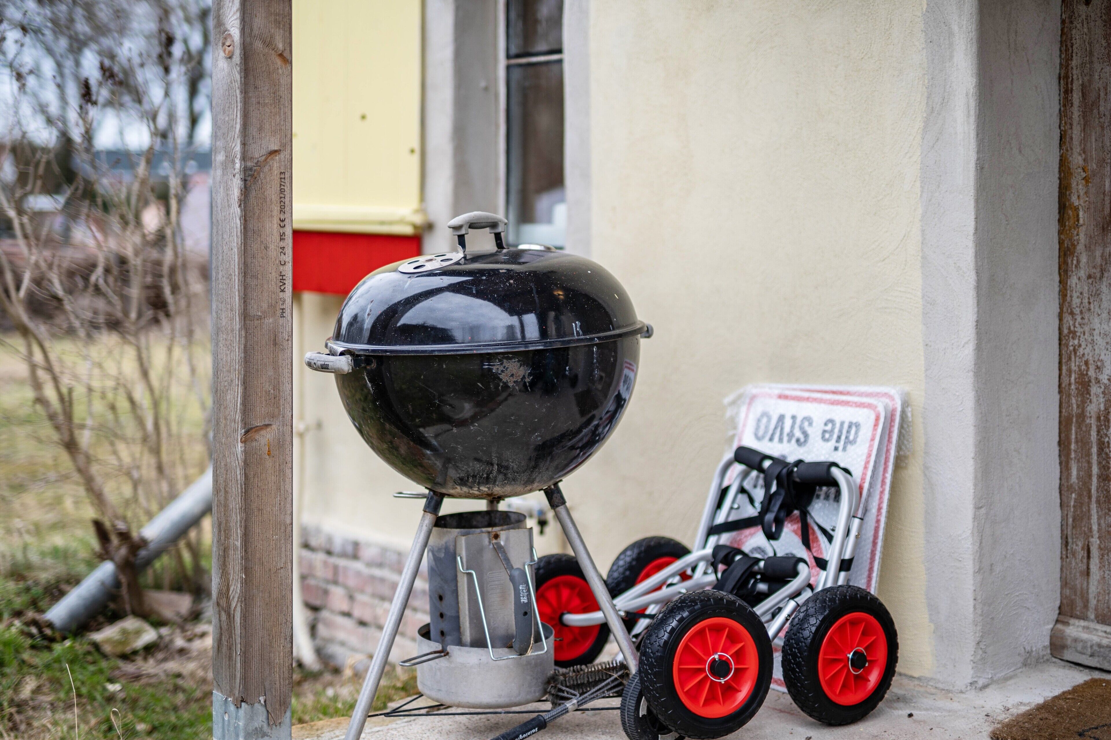 A portable grill and a wheelchair in front of a building.