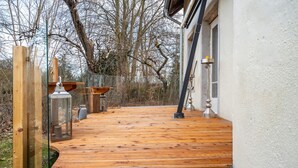 A wooden deck with a glass railing, a metal lantern, and a metal lamp post. - Holiday Home 'Seeblick' with Lake View, Private Terrace and Wi-Fi (Rheinsberg)