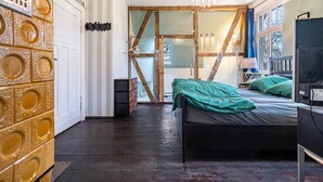 A bedroom with a bed, a dresser, a television, and a window with curtains. - Holiday Home 'Seeblick' with Lake View, Private Terrace and Wi-Fi (Rheinsberg)