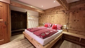 Un dormitorio de madera con cama, paredes y suelo de madera.