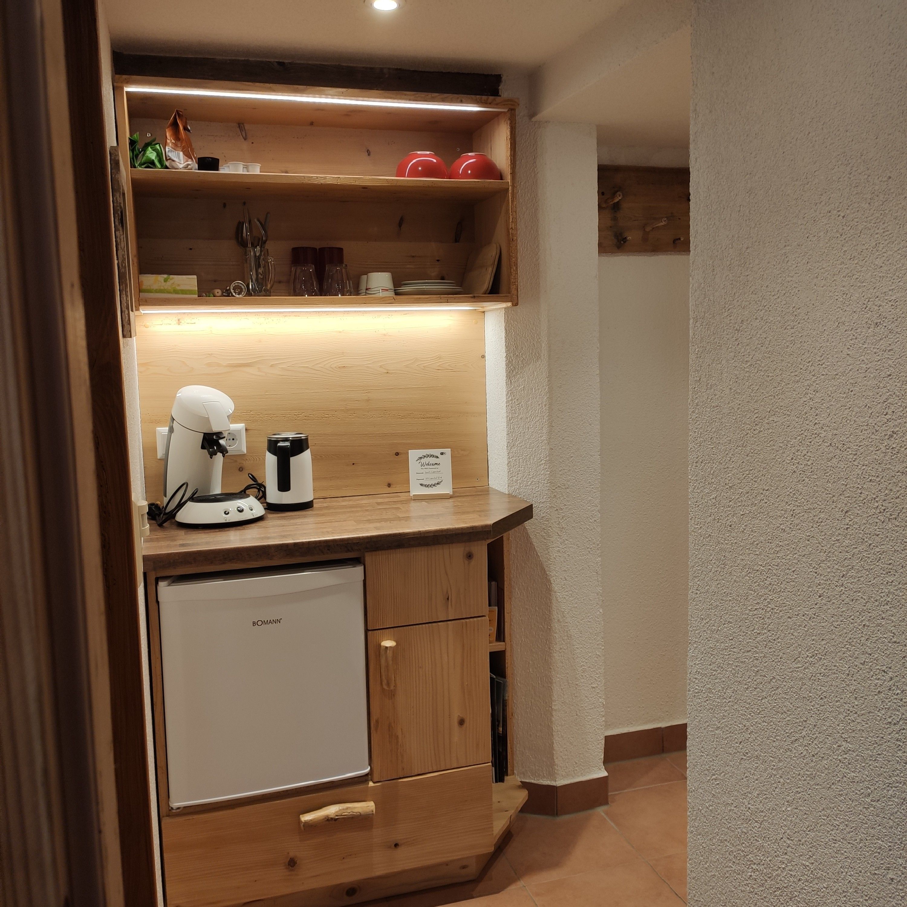 A compact kitchenette with a built-in refrigerator, a coffee maker, and a microwave.