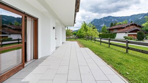 A modern building with large windows, a paved walkway, and a view of mountains. - Apartment 'Haus Katharina 2' with Mountain View, Private Terrace and Wi-Fi (Inzell)