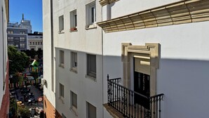 A white building with multiple windows and a balcony with black wrought iron railings. - Apartamento Las Palmeras - Ole Solutions (Jerez de la Frontera)