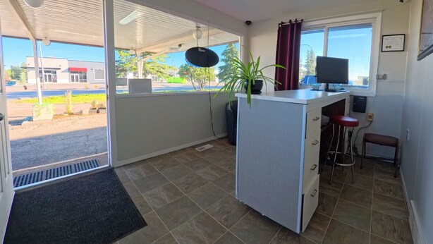 A small kitchenette with a window, a plant, and a TV. - Value Stay Clean Room at Castle Motel (Edson)