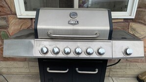 A stainless steel grill with multiple burners and a digital thermometer, mounted on a black grill cart with wheels. - Value Stay Clean Room at Castle Motel (Edson)