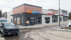 A commercial building with a 'Mary Brown's Chicken' sign, a 'Bakers Pizza & Donair' sign, and a 'Liquor' sign. - Value Stay Clean Room at Castle Motel (Edson)