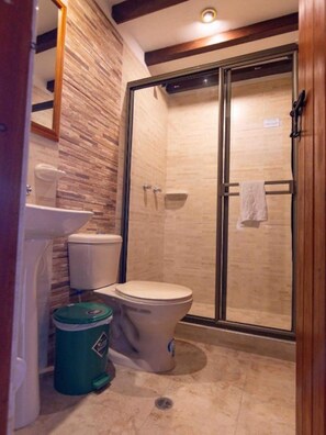 Een douche, handdoeken, zeep, toiletpapier