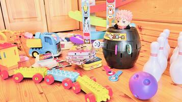 Children's play area features a toy train, car, bowling set, and puzzles.