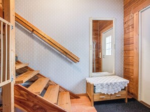 Eine Holztreppe führt zu einem Schlafzimmer mit einem hölzernen Bett und einem kleinen Nachttisch.