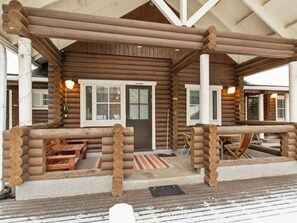 A log cabin with a porch, wooden benches, and a door labeled 'Orvokki'.