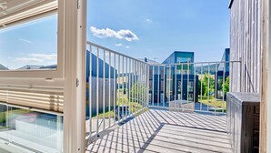 A balcony with a view of modern buildings and a clear sky. - Ore house by Interhome (Loucna pod Klínovcem)