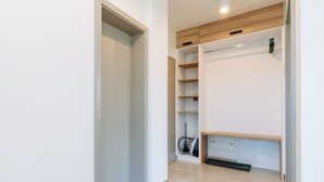 Ein moderner Kleiderschrank mit Holzböden, einem Staubsauger und einer Bank.